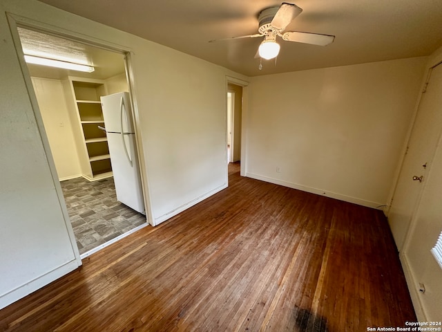 unfurnished bedroom featuring hardwood / wood-style floors, ceiling fan, and white refrigerator