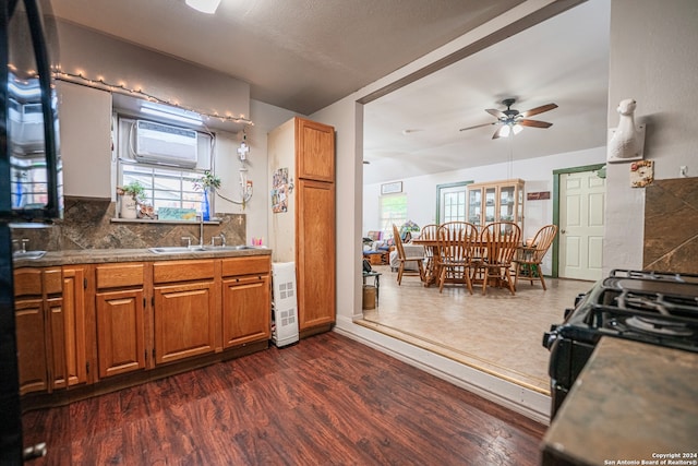 kitchen featuring backsplash, ceiling fan, range, sink, and dark hardwood / wood-style flooring