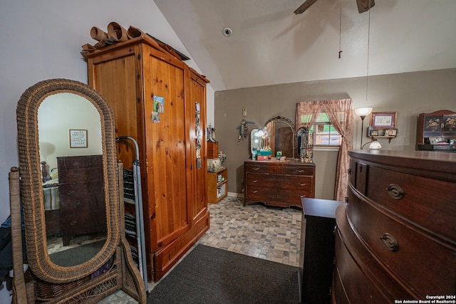 bedroom with ceiling fan, light tile floors, and lofted ceiling