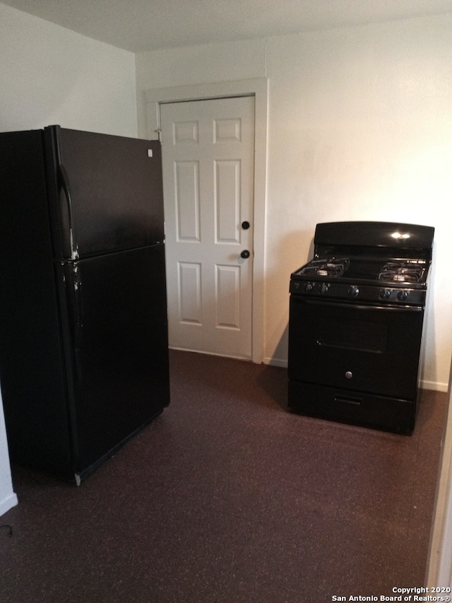 kitchen with dark carpet and black appliances