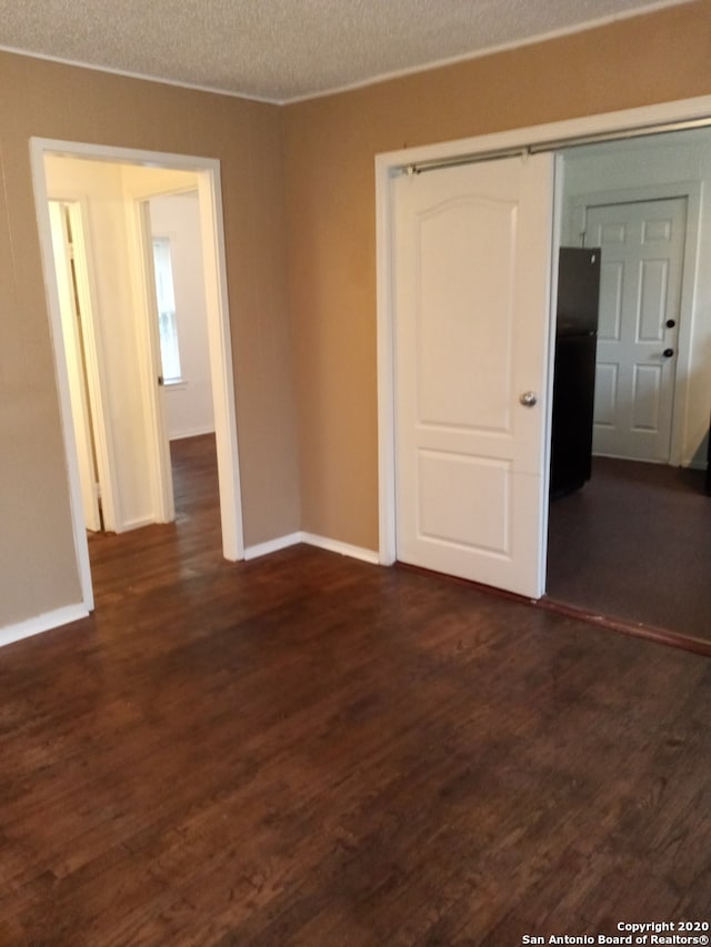 unfurnished room featuring dark hardwood / wood-style floors and a textured ceiling