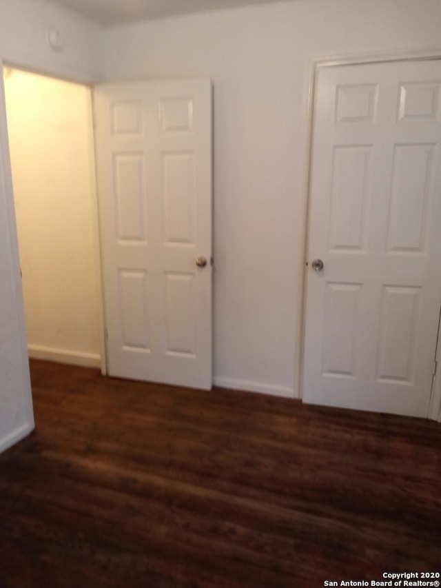 unfurnished room with dark hardwood / wood-style flooring