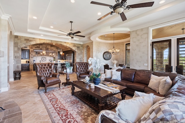 living room featuring light tile flooring, ceiling fan with notable chandelier, a raised ceiling, and crown molding