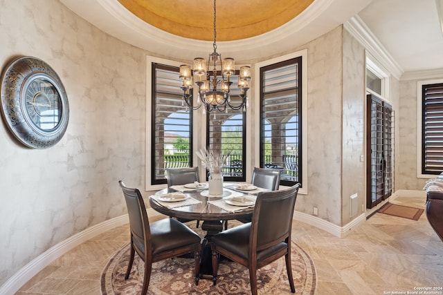 dining room with ornamental molding, a chandelier, and a raised ceiling