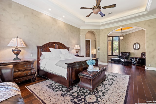 bedroom featuring ceiling fan, crown molding, a raised ceiling, and dark wood-type flooring