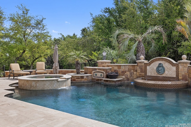 view of pool with a patio area, pool water feature, and an in ground hot tub