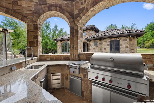 view of patio / terrace with grilling area, sink, and an outdoor kitchen