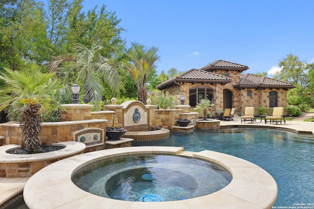 view of pool featuring a patio area and an in ground hot tub