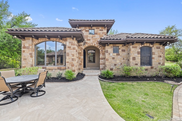 view of front of home with a front yard and a patio area