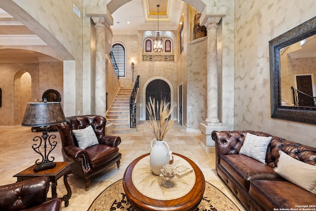 living room with tile flooring, crown molding, a high ceiling, and decorative columns