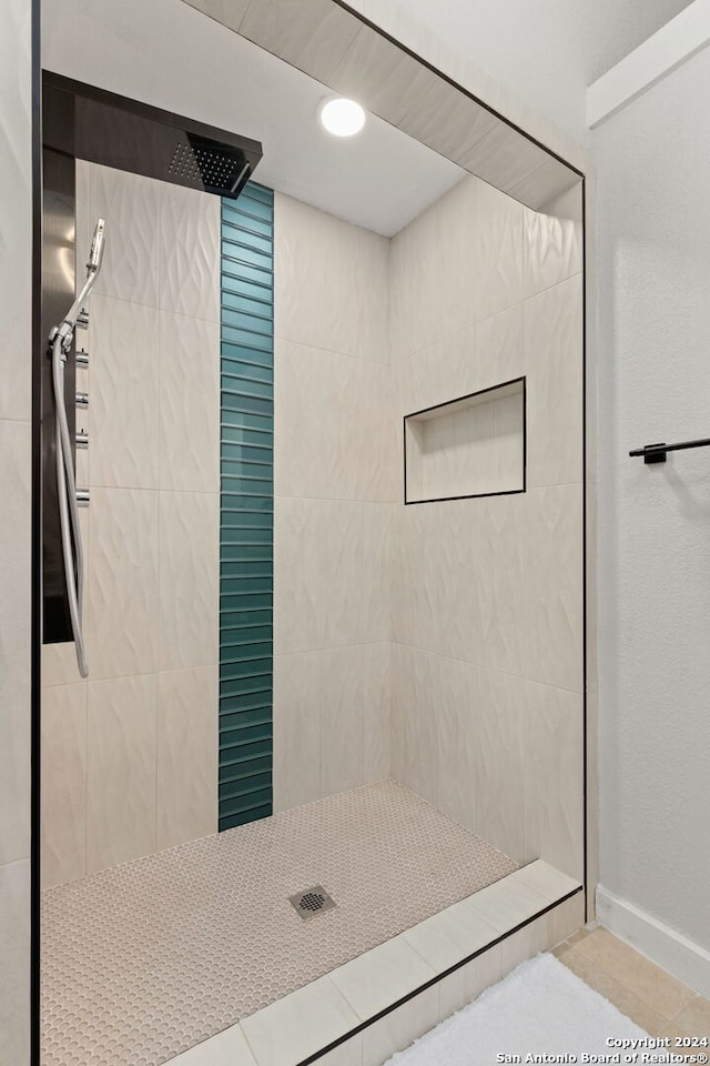 bathroom featuring a tile shower and tile flooring