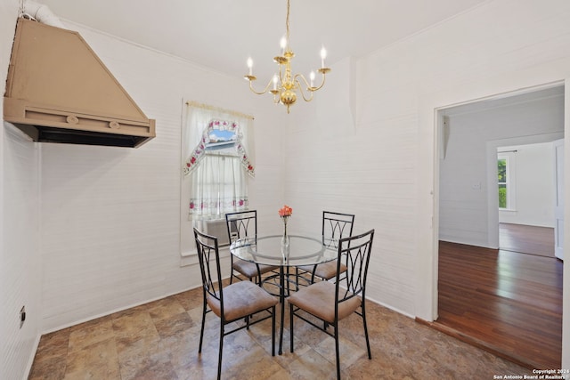 dining room featuring ornamental molding, an inviting chandelier, and tile flooring