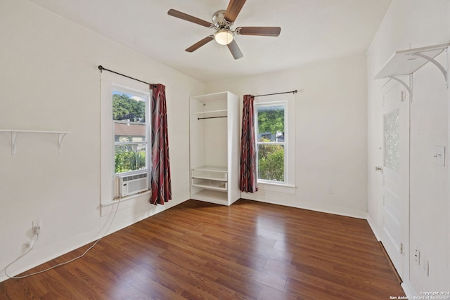 unfurnished room featuring a wealth of natural light, dark wood-type flooring, and ceiling fan