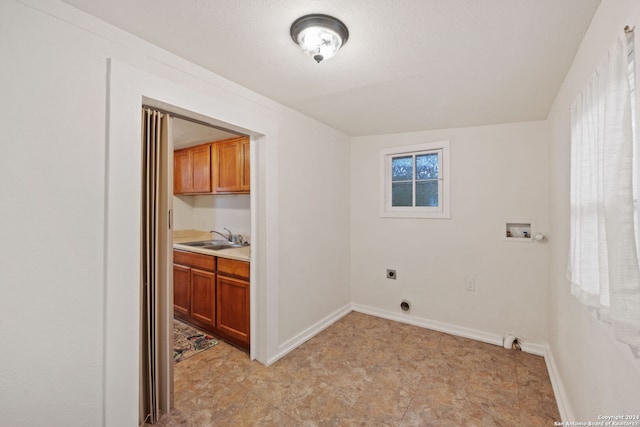 washroom with sink, hookup for an electric dryer, hookup for a washing machine, and light tile floors