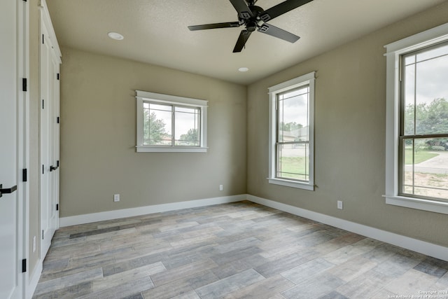 spare room with ceiling fan and light wood-type flooring