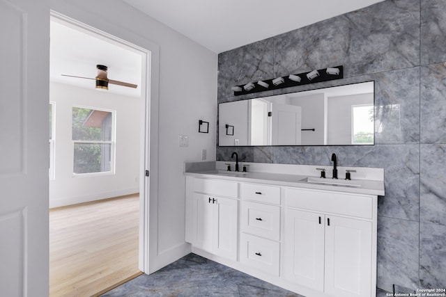 bathroom with hardwood / wood-style floors, double sink vanity, and tile walls