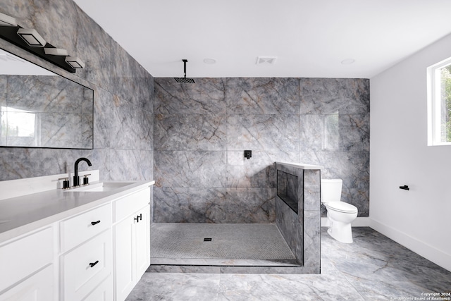 bathroom with tile flooring, tile walls, vanity, and toilet