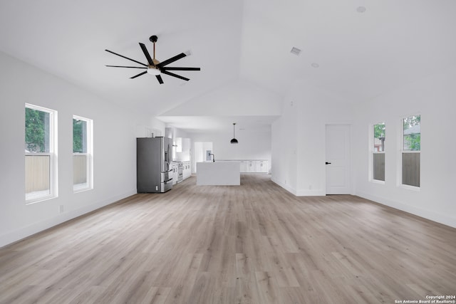 unfurnished living room with vaulted ceiling, ceiling fan, and light wood-type flooring