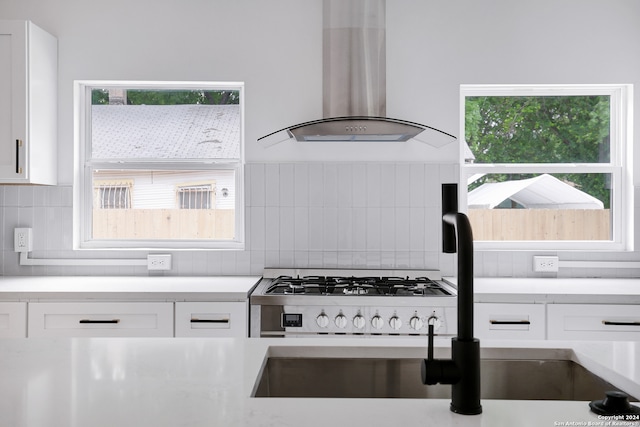 kitchen with white cabinetry, fume extractor, and backsplash