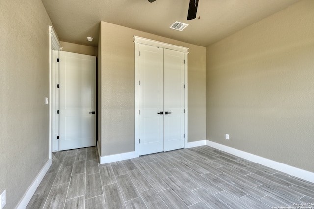 unfurnished bedroom with a closet, ceiling fan, and light wood-type flooring