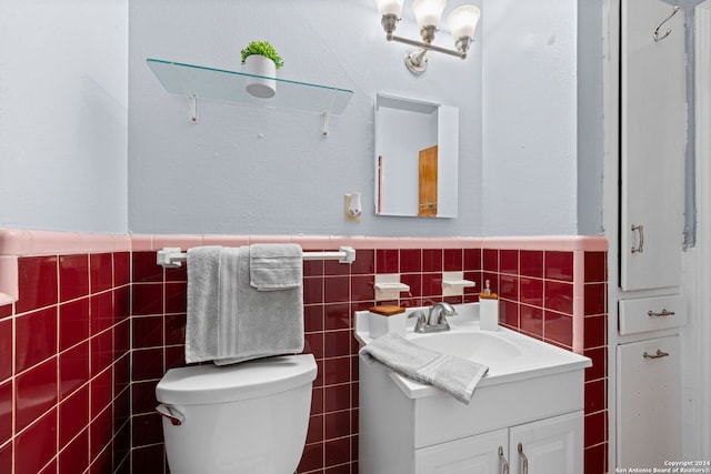 bathroom with tile walls, toilet, vanity, and decorative backsplash