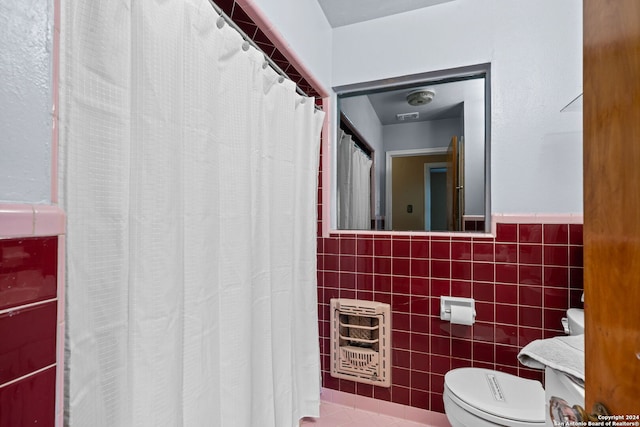 bathroom with tile walls, toilet, heating unit, and vanity