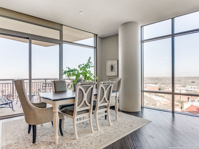 dining area with a healthy amount of sunlight, wood-type flooring, and expansive windows