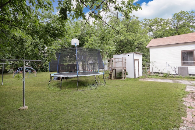 view of yard with a trampoline, central air condition unit, and an outdoor structure