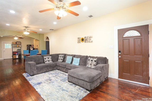 living room featuring ceiling fan and dark wood-type flooring