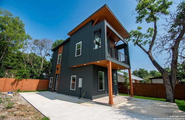 back of property with a patio area and a balcony