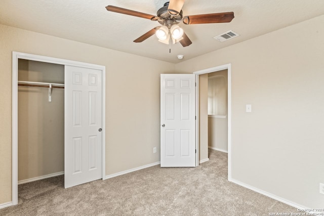 unfurnished bedroom featuring light colored carpet, a closet, and ceiling fan