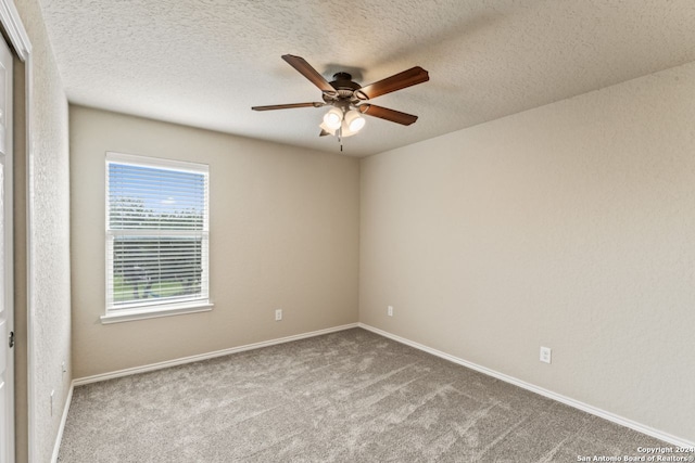 carpeted empty room with ceiling fan and a textured ceiling