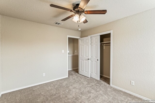 unfurnished bedroom featuring a closet, ceiling fan, and carpet