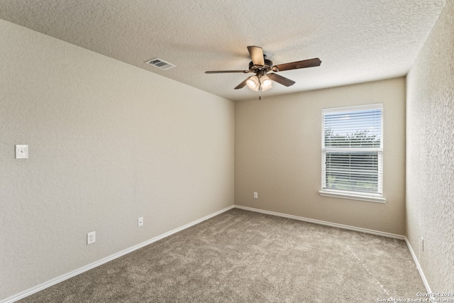 spare room featuring a textured ceiling, ceiling fan, and carpet floors