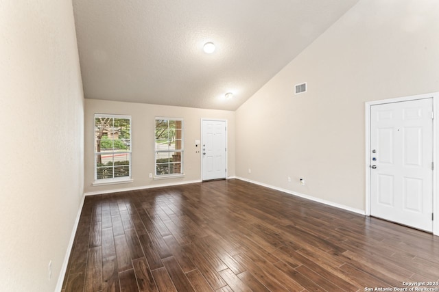 unfurnished living room with dark wood-type flooring and high vaulted ceiling