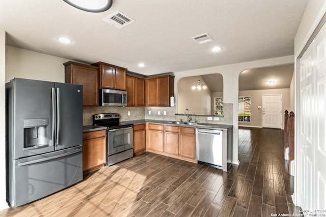 kitchen featuring tasteful backsplash, appliances with stainless steel finishes, dark wood-type flooring, and sink