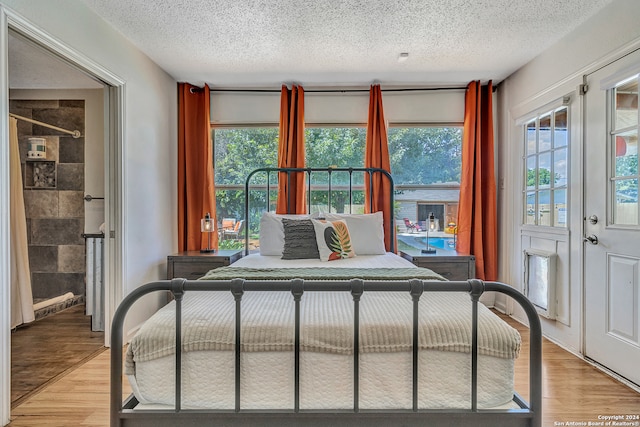 bedroom with hardwood / wood-style floors and a textured ceiling