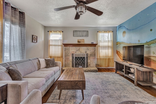 living room with a healthy amount of sunlight, ceiling fan, hardwood / wood-style floors, and a fireplace