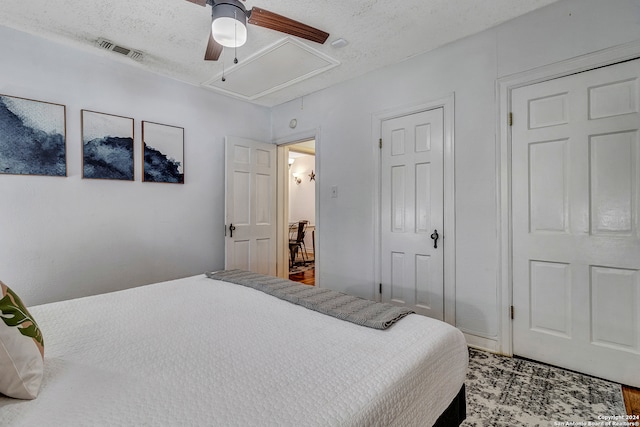 bedroom with ceiling fan, light hardwood / wood-style flooring, and a textured ceiling