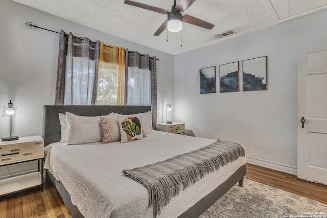 bedroom featuring dark wood-type flooring, ceiling fan, and a textured ceiling