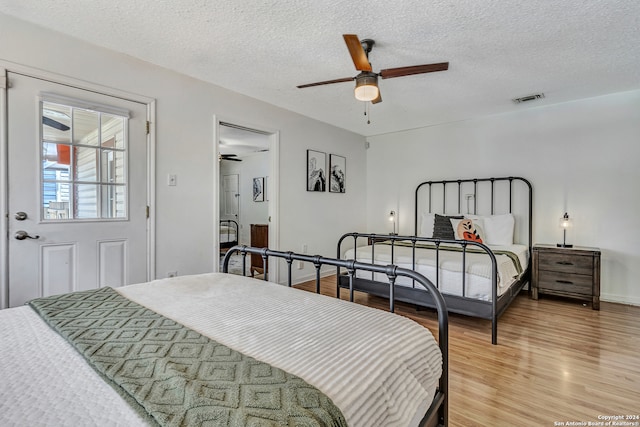 bedroom with a textured ceiling, ceiling fan, and hardwood / wood-style flooring