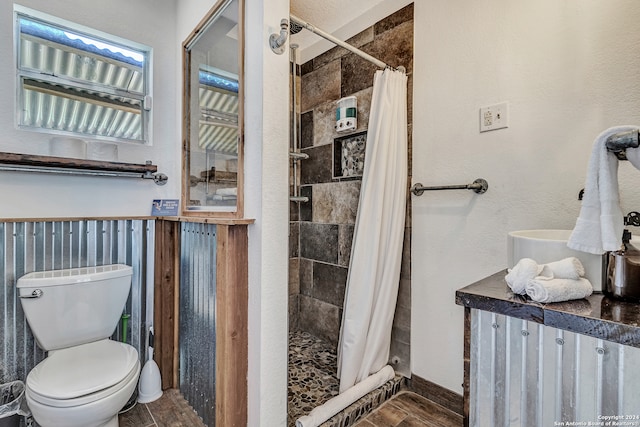 bathroom featuring hardwood / wood-style floors, toilet, and a shower with curtain