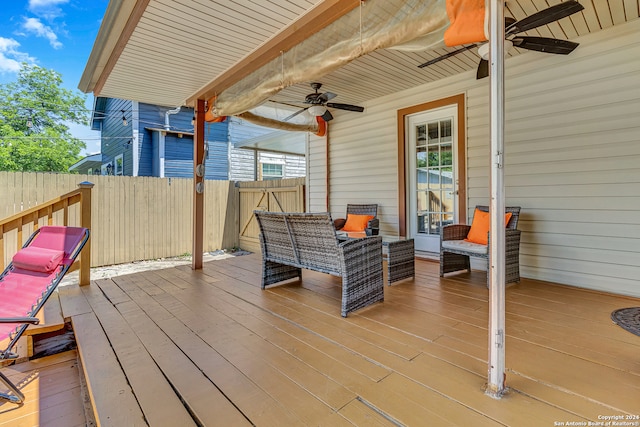 wooden terrace with an outdoor living space and ceiling fan