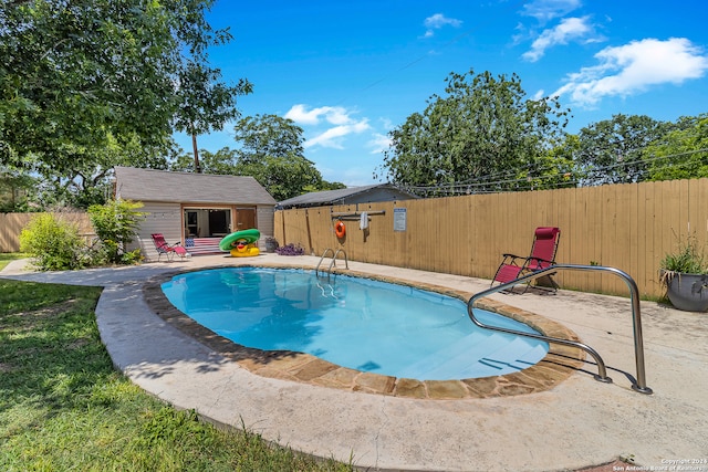 view of pool with a patio and an outdoor structure