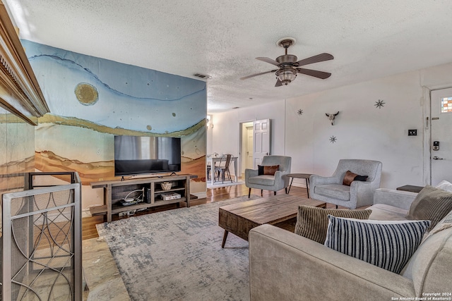 living room with wood-type flooring, a textured ceiling, and ceiling fan