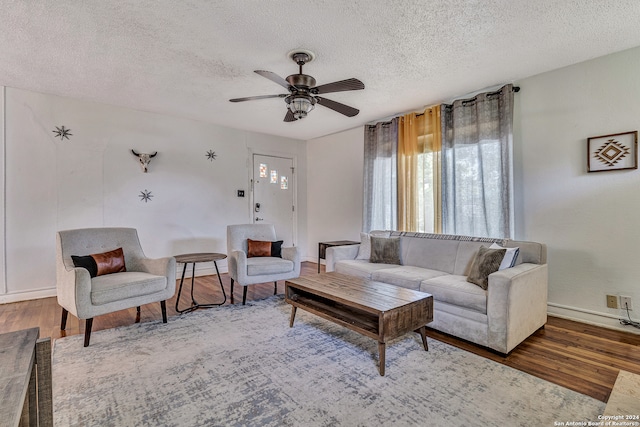 living room featuring hardwood / wood-style flooring, ceiling fan, and a textured ceiling