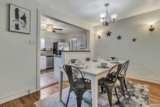 dining space featuring tile flooring, ceiling fan with notable chandelier, and a textured ceiling