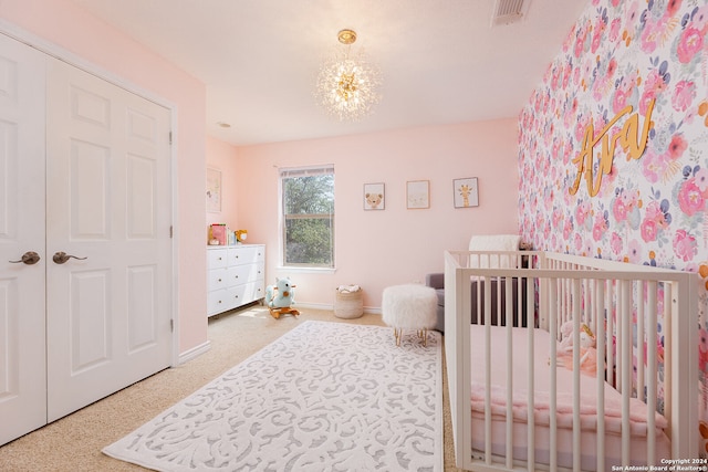 bedroom featuring a crib and a chandelier