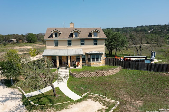 rear view of house with a lawn and covered porch