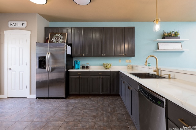 kitchen featuring pendant lighting, appliances with stainless steel finishes, sink, and dark brown cabinets